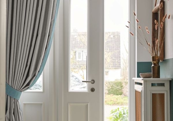 Drapes held by a tieback shileding a door to the outside in a classic residence in Prague